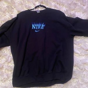 Black hoodie with blue Nike flames coming out of it.